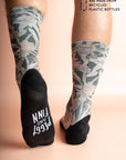 Charcoal grey socks decorated with colorful Australian flora including Banksia and Gum Leaves, crafted from recycled plastic bottles