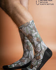 Eco-friendly grey socks featuring a unique Banksia pattern in shades of green, white, and burnt orange, made from recycled materials