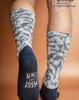 Soft and durable socks crafted from recycled bottles, decorated with a vibrant print of pink Flowering Gum blossoms against a blue background