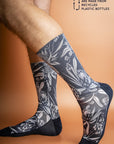 Sustainable socks made from recycled materials, adorned with a pattern of iconic Australian flora against a navy background