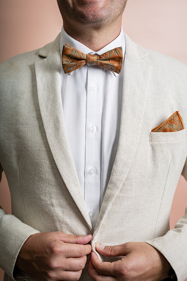 Modern and stylish bow tie featuring a detailed flowering gum print in terracotta, inspired by Australian native flora with vibrant red blossoms and green leaves for a striking look