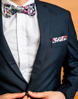 Modern and stylish bow tie featuring a detailed protea print in navy, complemented by shades of pink and green, reflecting the deep, rich tones of this flower
