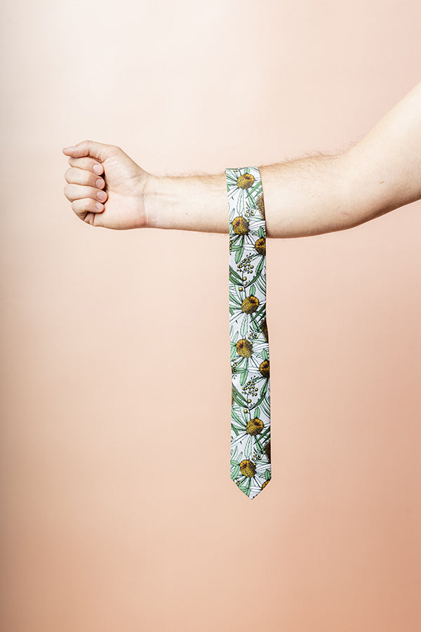 Elegant grey cotton tie featuring a Banksia flora pattern with green, white, and pastel yellow accents, inspired by Australia's native plants