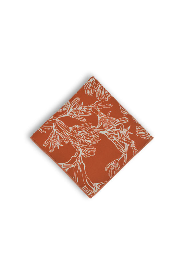 Chic pocket square with a burnt orange base, adorned with white outlines of the unique Kangaroo Paw flower, perfect for adding a pop of color to formal attire